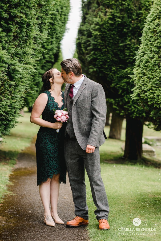 bride and groom kissing among trees wedding photos