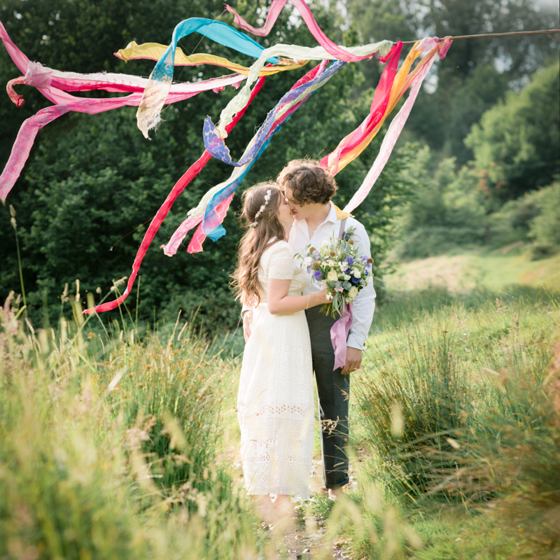 bride and groom in a field alternative colourful wedding 