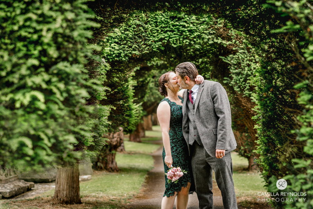 bride and groom kissing churchyard st marys church wedding  gloucestershire