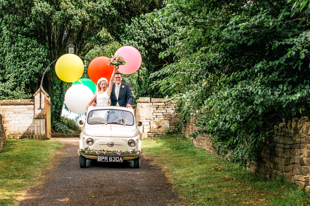 bride and groom car with colourful balloons fun wedding photography uk