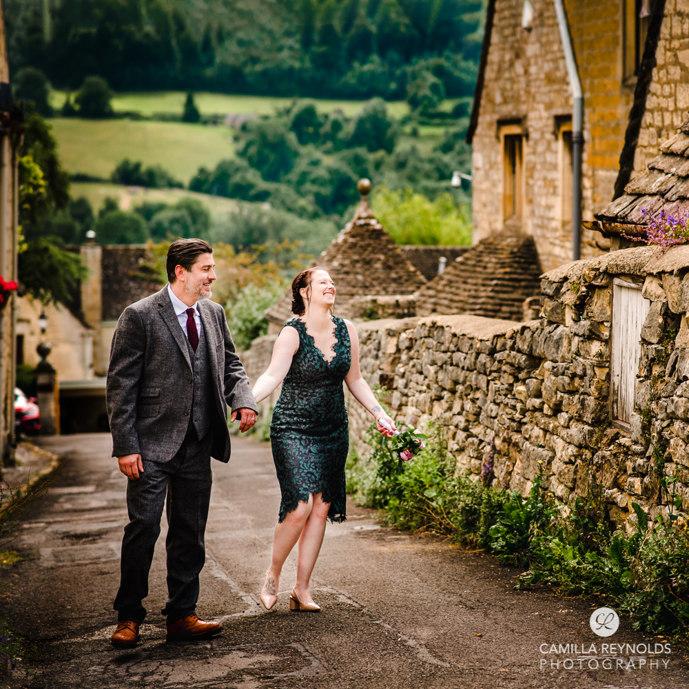 wedding couple walking in beautiful cotswold village countryside views