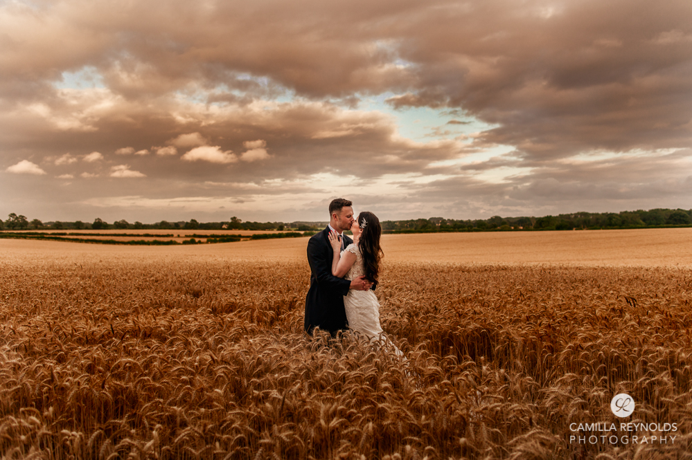 bride and groom kissing in field romantic wedding photography uk