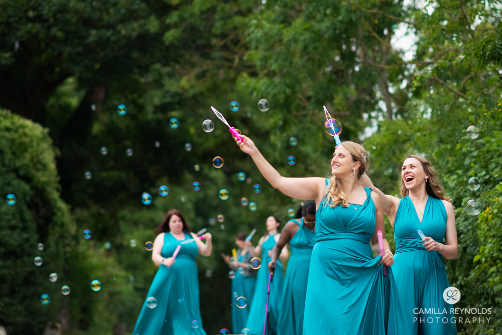 bridesmaids in blue dresses with bubbles natural wedding photography uk