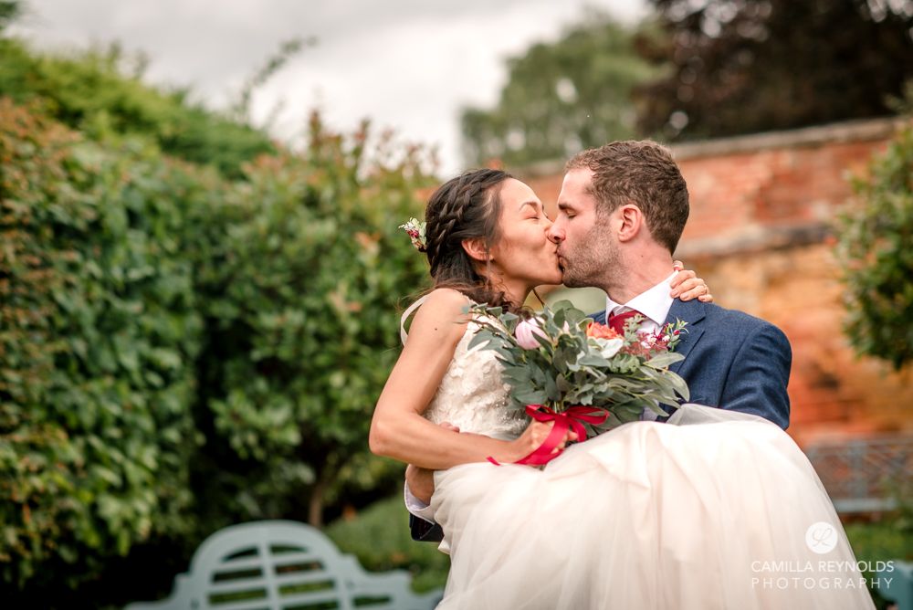 bride and groom kissing in garden wedding Cotswolds