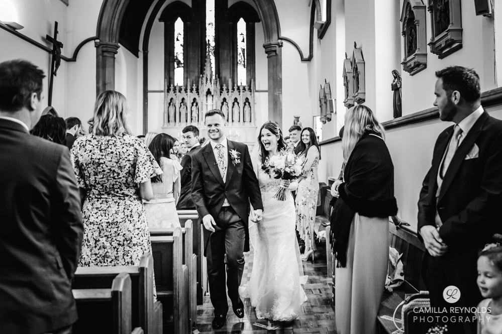 bride and groom walking cotswold wedding st peters church cirencester