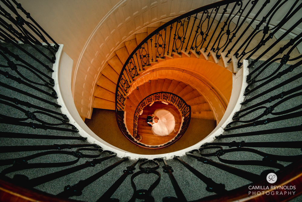 bride and groom on a beautiful spiral  staircase eastington park gloucsetershire uk