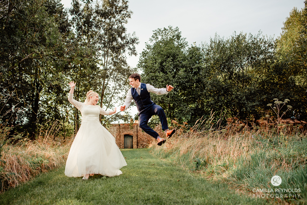 bride and groom jumping fun wedding photography cotswolds