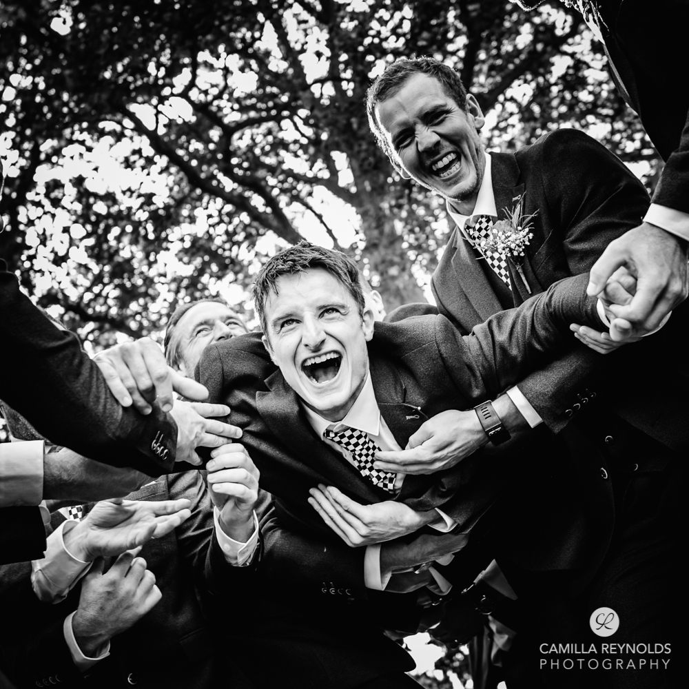 groom thrown in the air natural wedding photography Gloucestershire uk