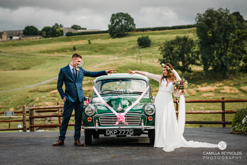 bride and groom with morris minor car wedding photography gloucestershire kingscote barn