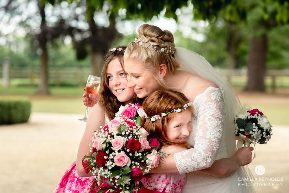 bride hugging bridesmaids natural wedding photography cotswolds uk