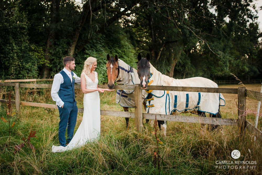 bride and groom with horses Cotswold wedding Gloucestershire uk
