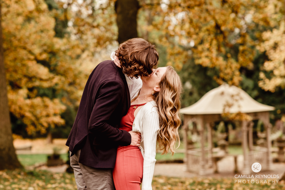 couple kissing in autumn forest at eastington park wedding venue gloucestershire