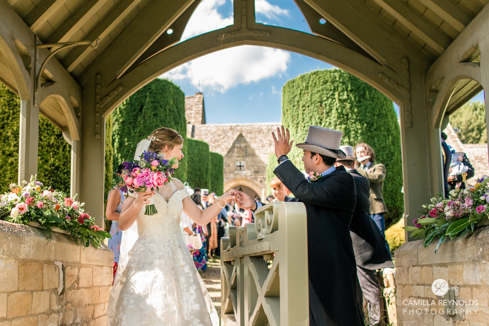bride and groom waving cotswold church wedding 