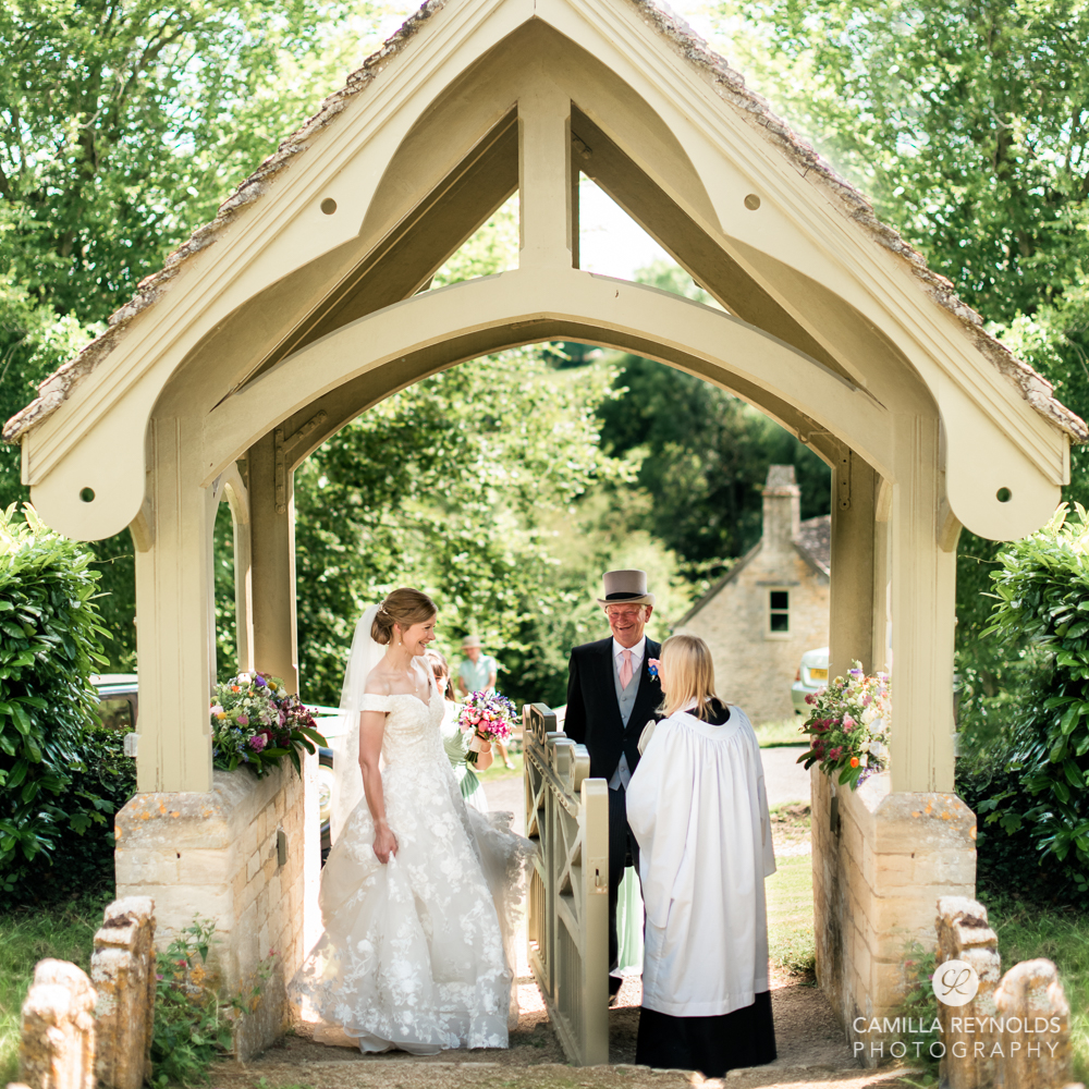 bride under church arch cotswold wedding photography