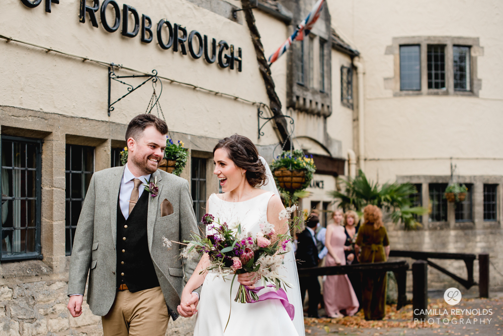 bride and groom walking  bear of rodborough hotel cotswolds