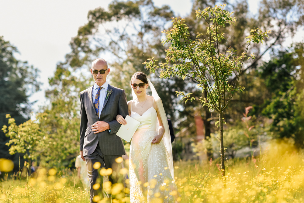 bride walking summer meadow matara cotswolds