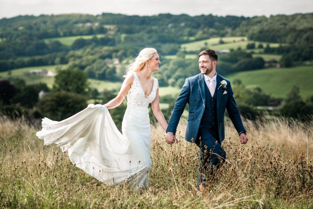 bride and groom walking in countryside cotswolds  wedding photography
