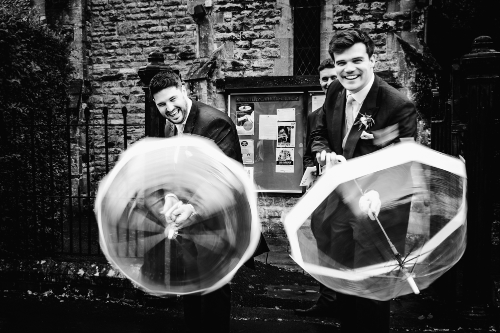 groomsmen with umbrellas fun wedding photography cripps barn