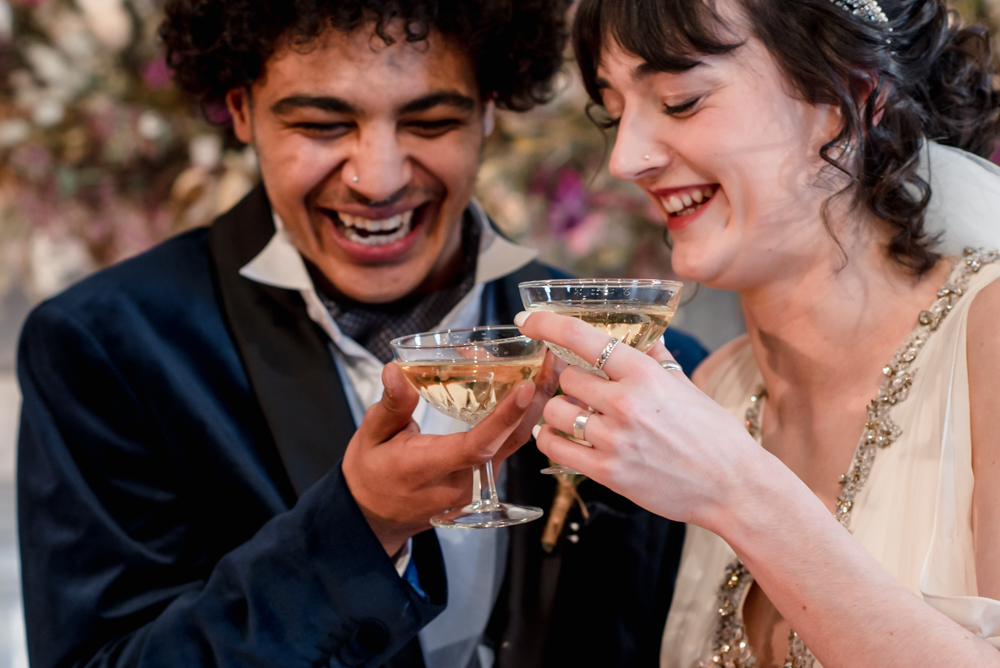 bride and groom laughing vintage champagne glasses