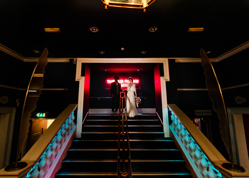 bride and groom on dramatic  staircase stroud sub rooms gloucestershire