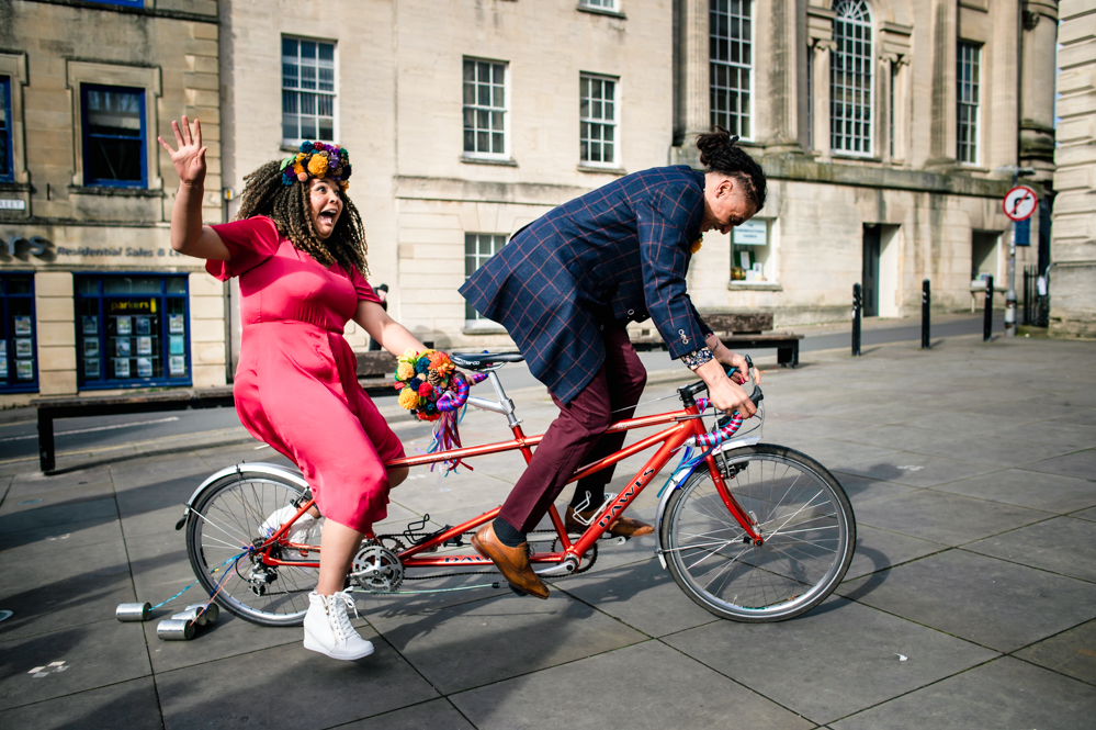 bride and groom riding tandem bicycle stroud