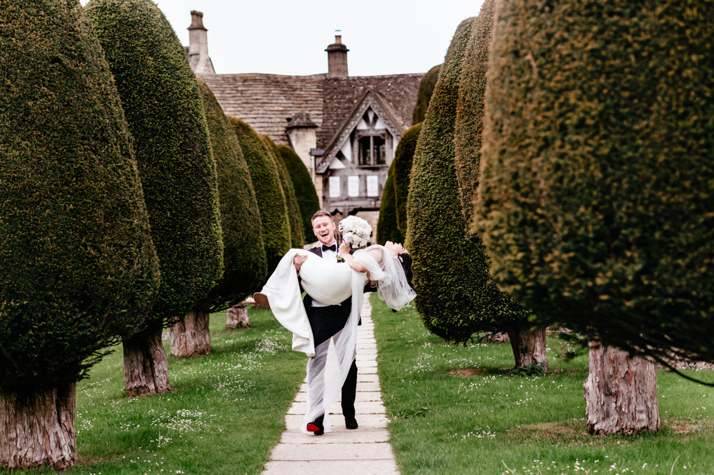 groom carrying bride paiswick cotswolds