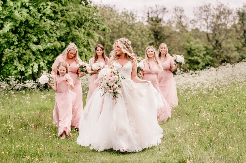 bride walking in the field cotswolds