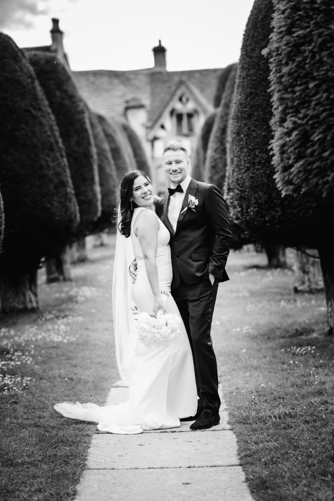 bride and groom  in the church yard cotswolds