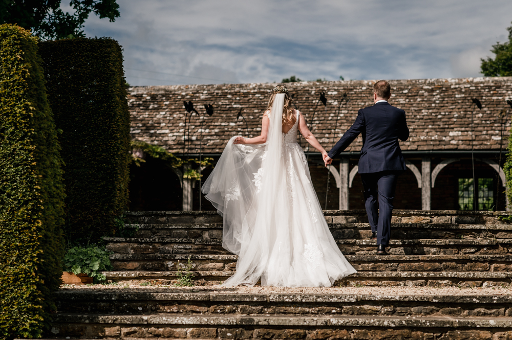 bride and groom walking up steps whatley manor
