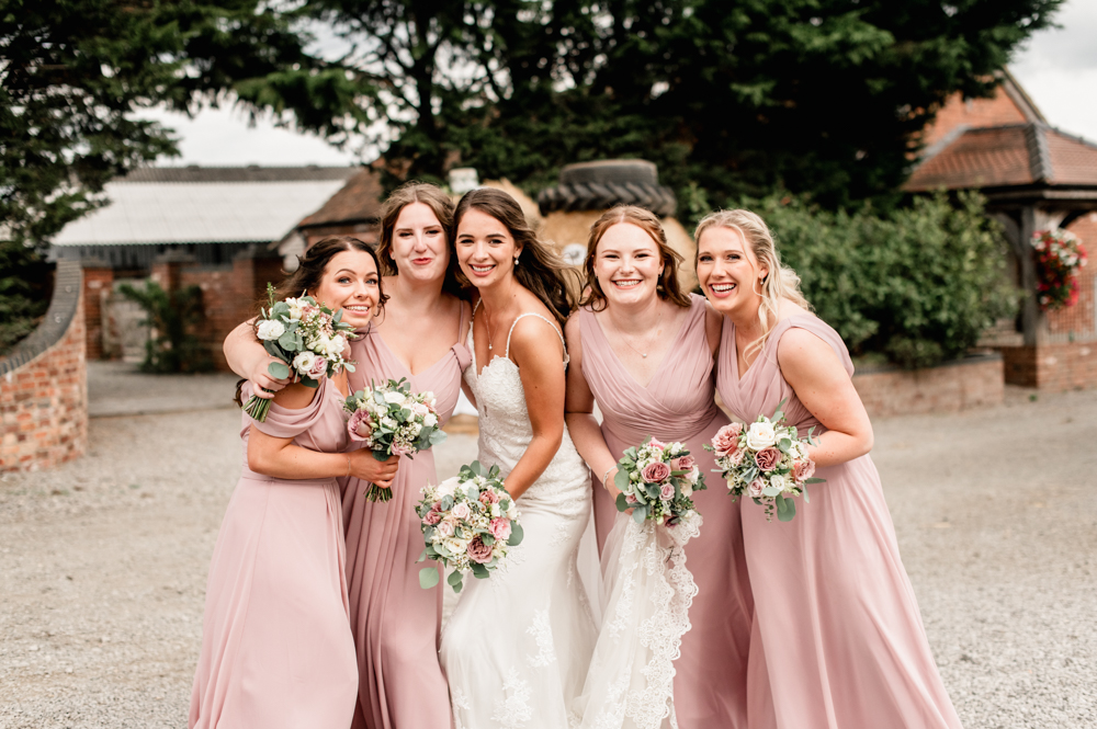bride and bridesmaids pink dresses hugging