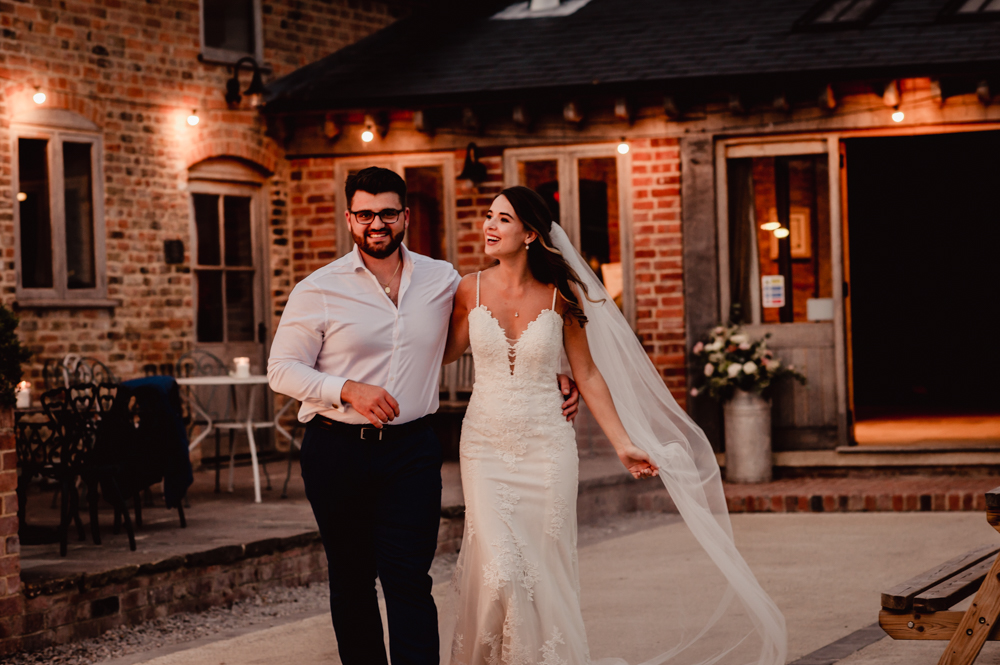 couple walking milton end barn wedding venue gloucestershire