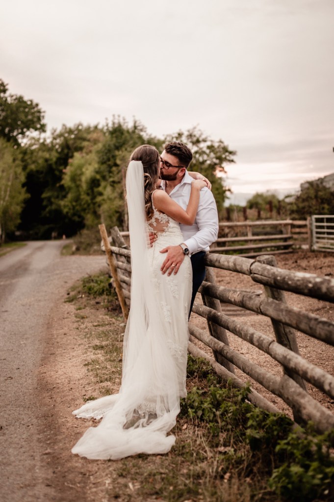 bride and groom kissing farm cotswold wedding