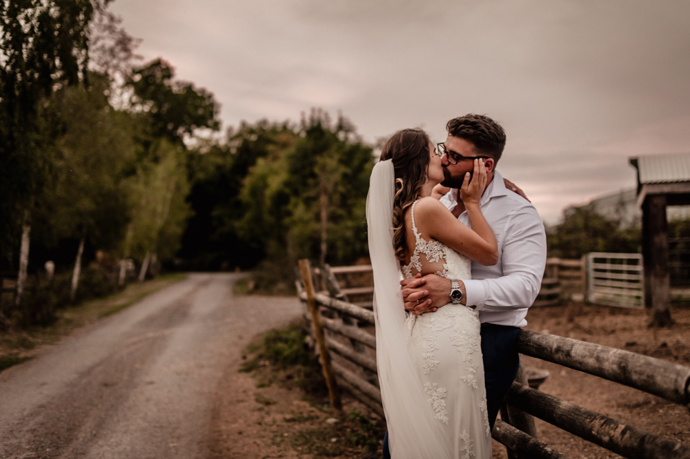 bride and groom kissing countryside cotswolds