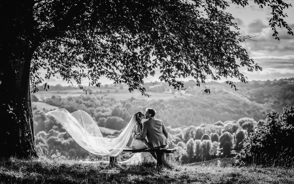 bride and groom kissing under tree