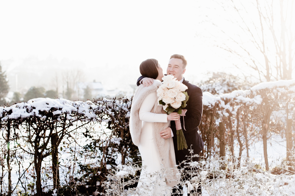 bride groom hugging in snow