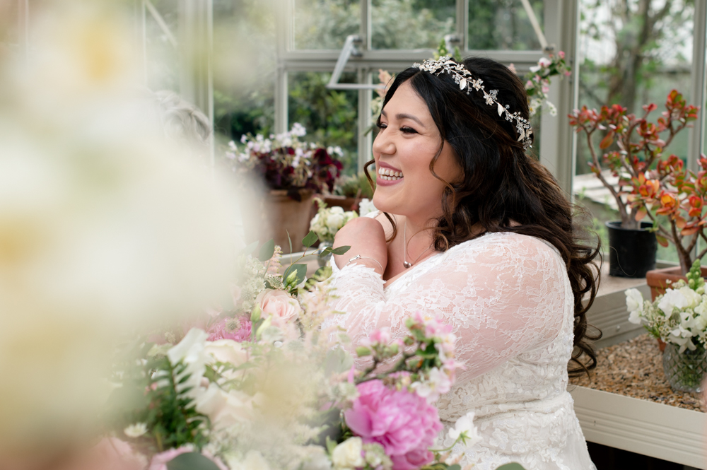 bride smiling in flowers light airy wedding photos