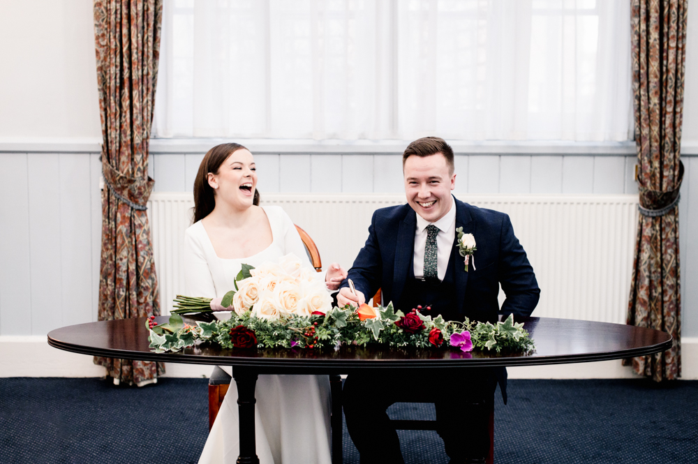 bride and groom signing  stroud registry office wedding