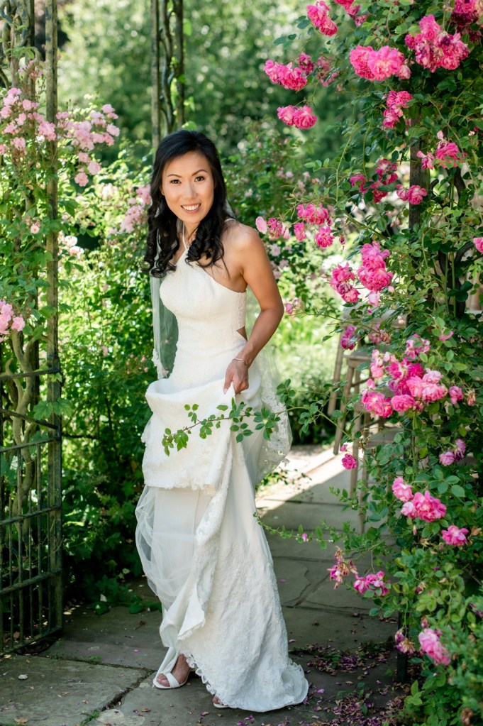bride under rose arch in vera wang wedding dress
