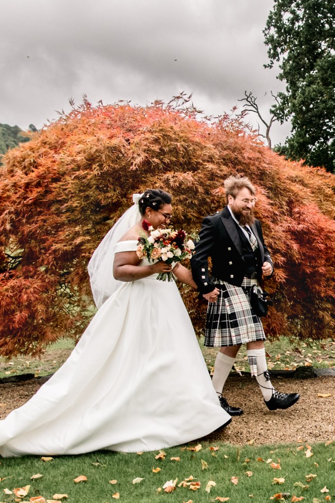 bride and groom walking autumn leaves