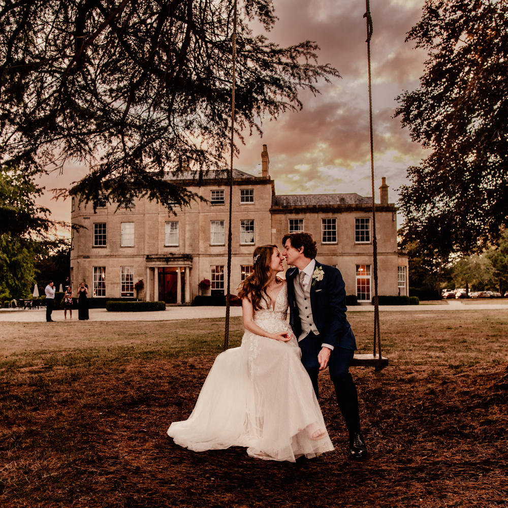 bride and groom on a swing  cotswolds