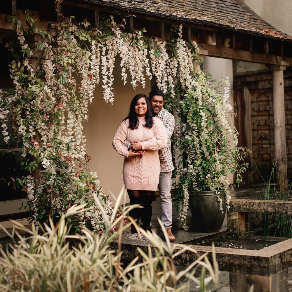 couple under wisteria engagement photo shoot
