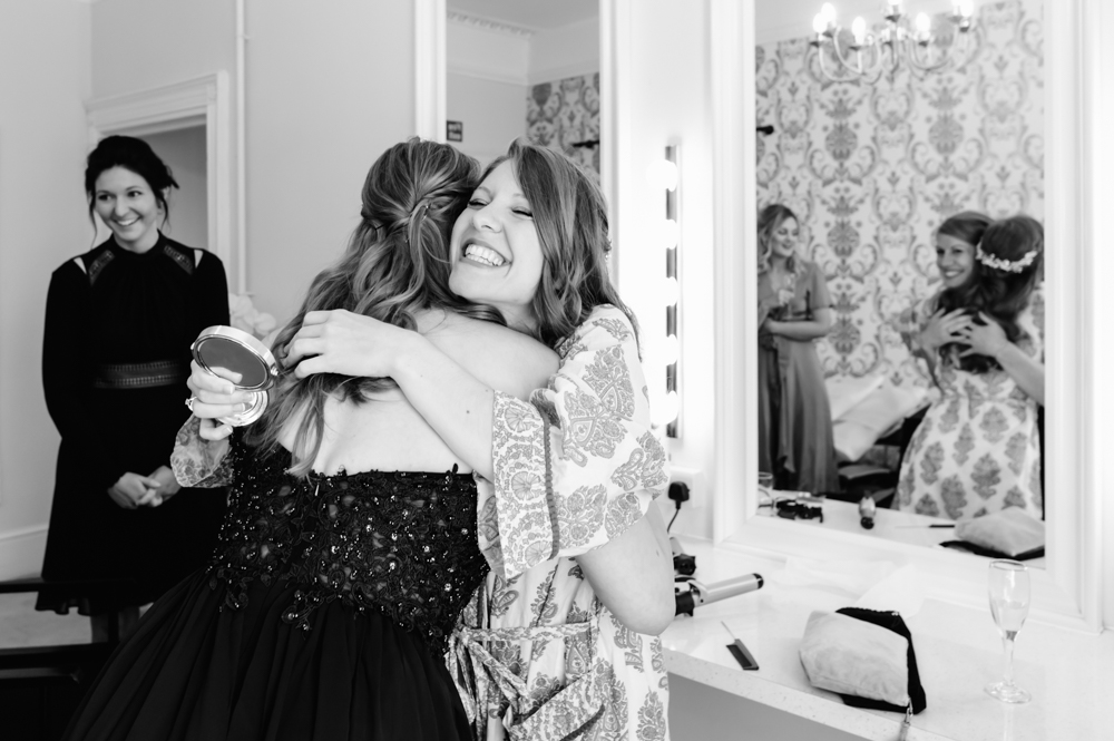 bride hugging bridesmaid eastington park 