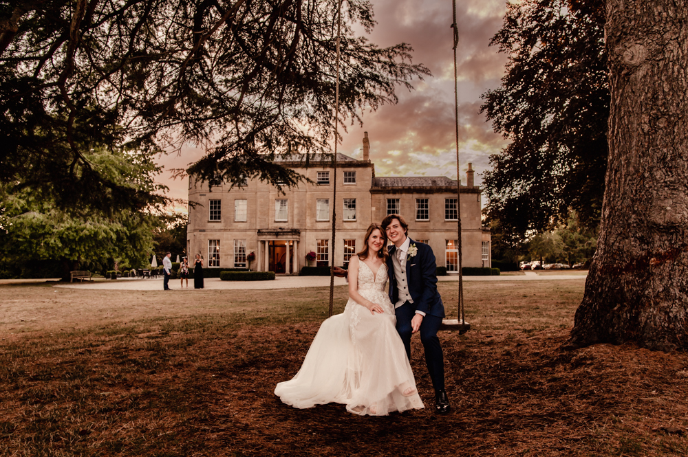 bride and groom on a swing  eastington park cotswolds