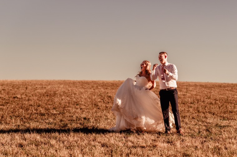 bride and groom laughing in countryside  