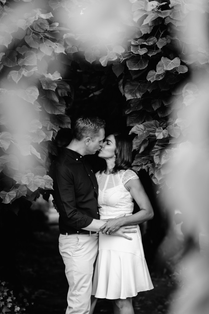 couple kissing among trees