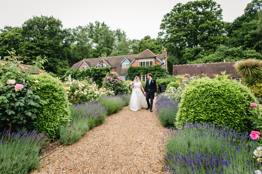 bride and groom walking through garden