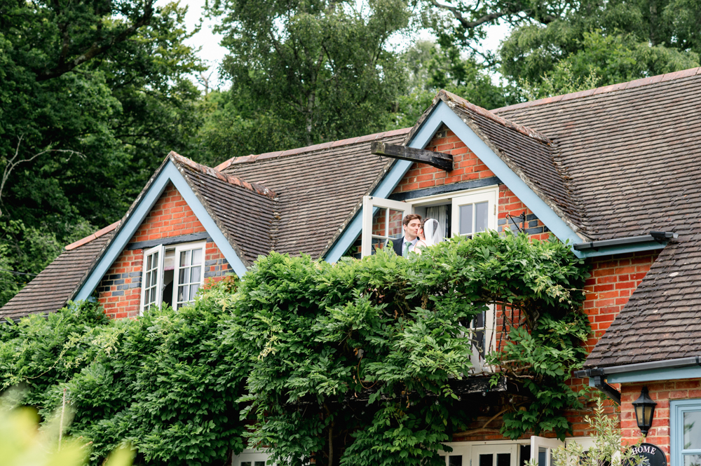 bride and groom kissing on balcony