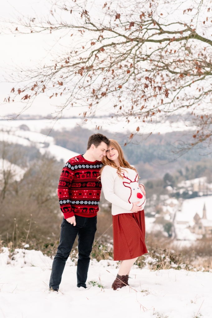 couple in christmas jumpers snow