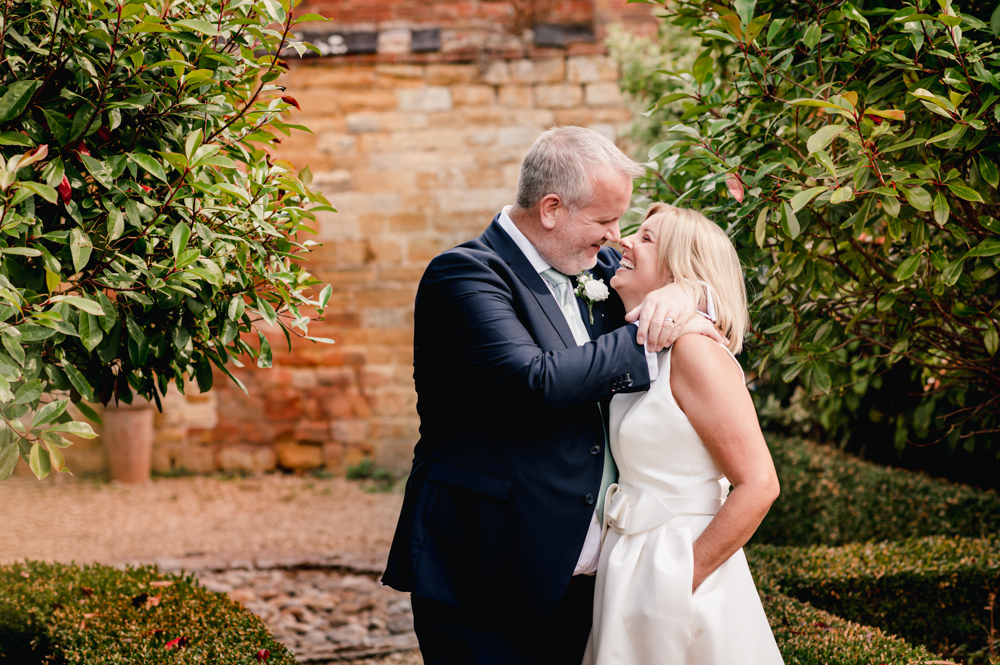 bride and groom hugging manor house hotel moreton in marsh