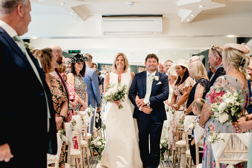 bride walking down aisle manor house hotel cotswolds
